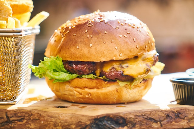 a cheeseburger and fries on a wooden slab